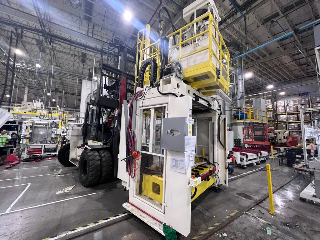 Montacargas de alta capacidad moviendo una prensa en planta