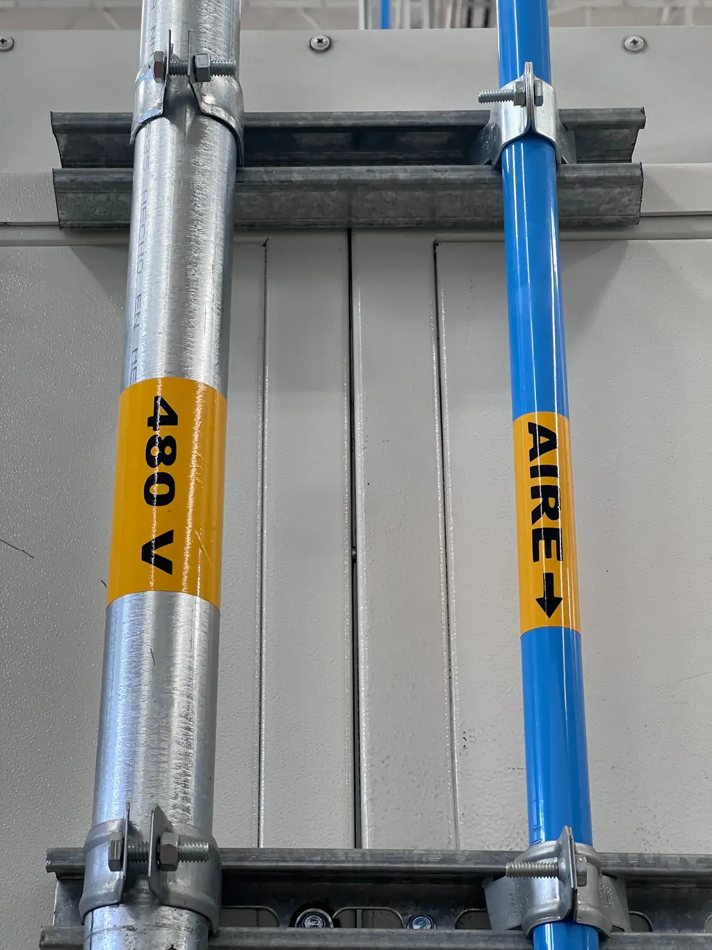 Labeled compressed air line and 480 V conduit